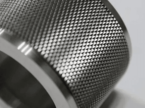 Close-up of a metal object with a textured, diamond pattern surface.