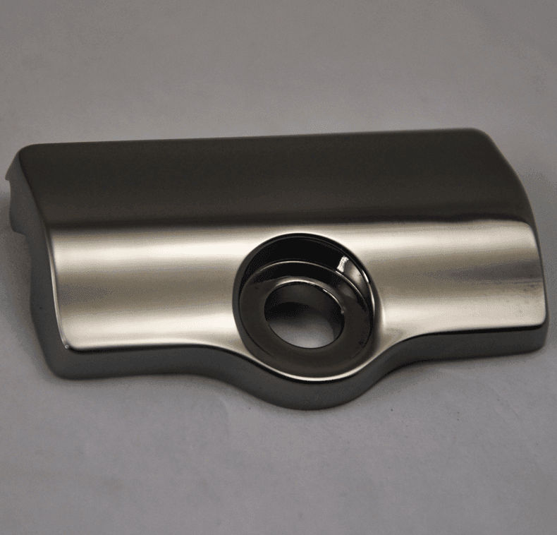 Chrome-plated metal component with a round hole in the center, placed on a plain surface.